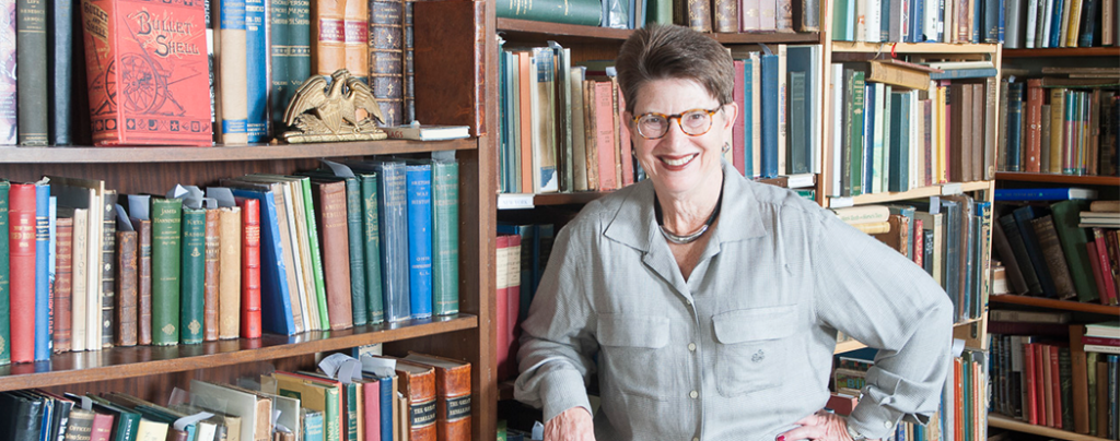 Andi Simon by a bookshelf